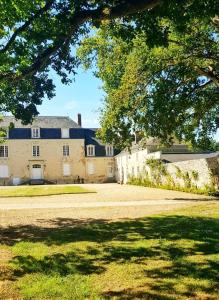 une grande maison avec une grande cour en face dans l'établissement Bel appartement à la Chetardière, à Sainte-Gemme-dʼAndigné