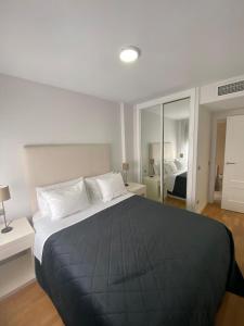 a bedroom with a large bed with a black blanket at Bausa 19 in Madrid