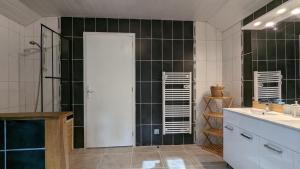 baño con paredes de azulejos negros y ducha. en La Belle Noue, en Bellenod-sur-Seine 54 fotos más