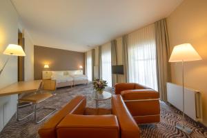ノルダーナイにあるMichels Thalasso Hotel Nordseehausのソファとリビングルームが備わるホテルルームです。