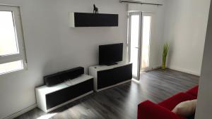sala de estar con TV de pantalla plana en la pared en Royal Family Apartment, en Chirivella