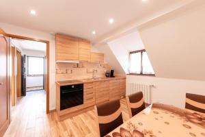 a kitchen with wooden cabinets and a table with chairs at L'Escapade Citadine in Bischheim +5 photos
