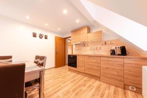 a large kitchen with wooden cabinets and a table at L'Escapade Citadine in Bischheim