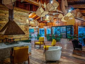 un restaurante con paredes de madera, sillas y mesas en Cloud Forest Lodge by Böëna, en Monteverde