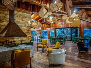 un restaurante con paredes de madera, sillas y mesas en Cloud Forest Lodge, en Monteverde