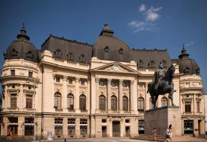 a large building with a statue in front of it at Tania-Frankfurt Hotel in Bucharest