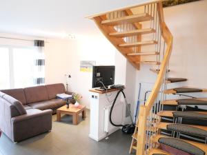 salon z kanapą i drewnianymi schodami w obiekcie Strandnah 12 Pers Gruppenhaus K8 w mieście Zierow