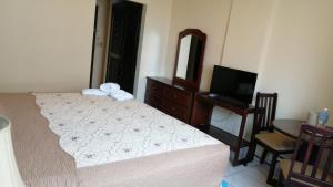 a bedroom with a bed and a table and a television at Hotel Palace Ejecutivo in San Pedro Sula