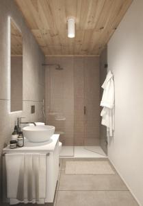 a bathroom with a white sink and a shower at The Base Andermatt in Andermatt