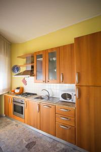 a kitchen with wooden cabinets and a sink and a refrigerator at "Casa incantevole" fronte mare Pescara in Pescara
