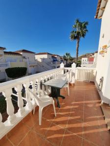 einen Balkon mit einem Tisch und einer Palme in der Unterkunft casa el Eden nudista in Playas de Vera