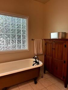 a bathroom with a bath tub and a window at Cozy Cabin w/ Indoor Fireplace & Tranquil views in Luray