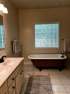 baño con bañera grande y ventana en Cozy Cabin w/ Indoor Fireplace & Tranquil views, en Luray
