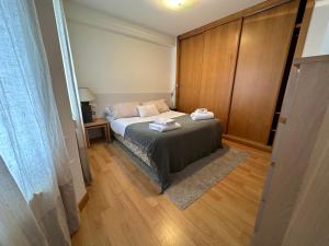 małą sypialnię z łóżkiem i drewnianą ścianą w obiekcie Oktheway Santander Street w mieście A Coruña