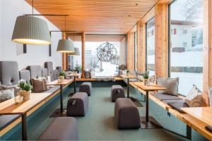 a room with couches and tables and windows at Hotel Sonne in Brand
