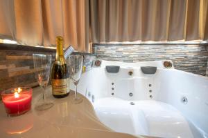 a bottle of wine and two glasses on a bath tub at Virtus Prestige - Rooms & Apartments in Rome