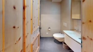 a bathroom with a toilet and a sink at Tschuetta in Celerina +12 photos