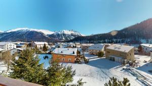 a town covered in snow with mountains in the background at Tschuetta in Celerina