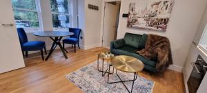a living room with a green couch and a table at Ritual Stays stylish 1-Bed Flat in the Heart of St Albans City Centre with Working Space and Super Fast WiFi in Saint Albans