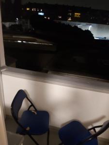 zwei blaue Stühle vor einem Fenster in der Unterkunft 1 Zimmerwohnung mit Küche, Balkon und Badezimmer in Düsseldorf Apartmen in Düsseldorf