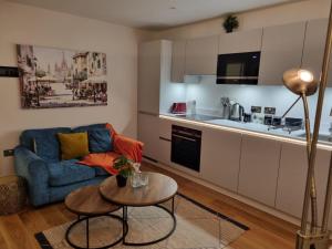a living room with a blue couch and a table at Ritual Stays stylish 1-Bed Flat in the Heart of St Albans City Centre with Working Space and Super Fast WiFi in St. Albans