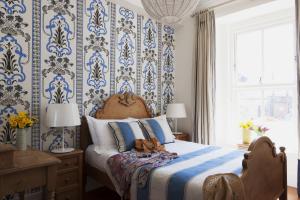 a bedroom with a bed with blue and white wallpaper at The Townhouse Strand in Dunmore East