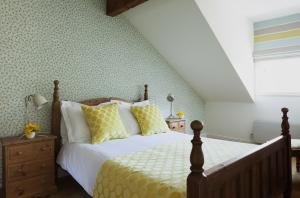 a bedroom with a bed with yellow and white pillows at The Townhouse Strand in Dunmore East