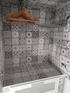 La salle de bains est pourvue d'un mur carrelé et d'une étagère. dans l'établissement Charmant appartement cosy, à Sélestat