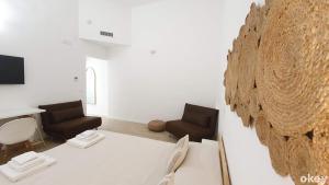 a living room with two chairs and a table at Dimora Beluga - Bari Centro in Bari