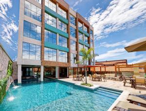 Una vista exterior de un edificio con piscina. en Gaeta Hotel, en Guarapari