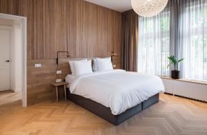 a bedroom with a large bed and a large window at Hotel Arena in Amsterdam