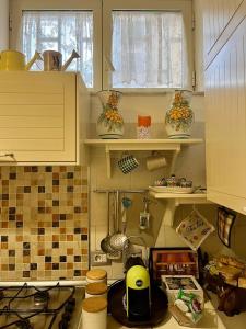 una cucina con bancone e piatti sugli scaffali di Vomero House with Free Parking 410 cm a Napoli
