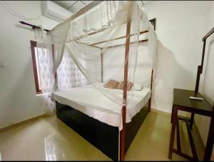 1 dormitorio con cama con dosel en Surf Villa Hiriketiya en Matara