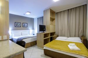 Habitación de hotel con 2 camas y TV en Interclass Florianópolis, en Florianópolis