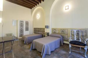 ヘレス・デ・ラ・フロンテーラにあるAlojamiento centro Jerezの紫のシーツとテーブルが備わるベッド2台が備わる客室です。