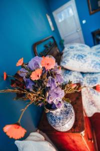 un jarrón lleno de flores moradas y naranjas en una mesa en B&B en Provence- Villa Saint Marc en Forcalquier