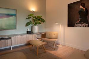 a living room with a chair and a painting on the wall at Hotel Arena in Amsterdam