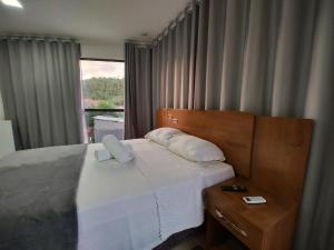 1 dormitorio con 1 cama grande y ventana en Flats Paraíso Louveny en Japaratinga