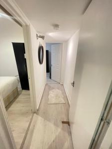a hallway leading to a bedroom with a bed and a mirror at Miles 4floor in London