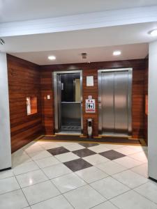 a lobby with two elevators and a checkered floor at BOA VIAGEM FLAT 106 in Recife