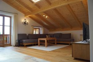 a living room with two couches and a tv at Fembacher Alm in Seeon-Seebruck