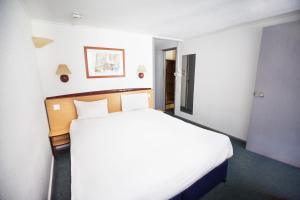 a bedroom with a large white bed in a room at Campanile Hotel Runcorn in Runcorn