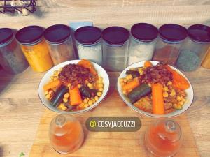 een tafel met drie borden voedsel met wortels en bonen bij Cosy jacuzzi in Orange