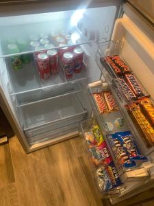 an open refrigerator filled with drinks and snacks at Cosy jacuzzi in Orange