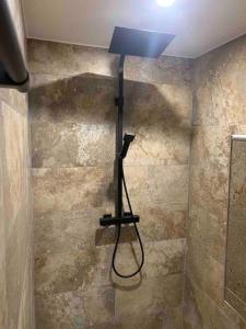 uma casa de banho com chuveiro e luz na parede em Cosy jacuzzi em Orange