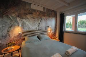 a bedroom with a bed and a stone wall at Tenuta Bussete Country Hotel in Viterbo