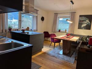 a kitchen with a sink and a table in it at Kallis Appartement in Mayrhofen