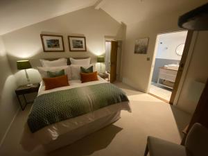 a bedroom with a large bed and a bathroom at Gower Villa Luxury Cottage, 2 bedroom en-suite with Hot Tub in Clynderwen