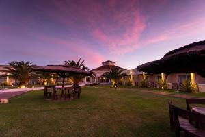 ein Resort mit Tischen und Sonnenschirmen auf einem Hof in der Unterkunft Melincue Casino & Resort in Melincué