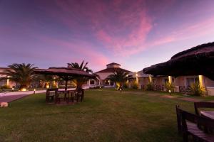 a resort with tables and umbrellas in a yard at Melincue Casino & Resort in Melincué